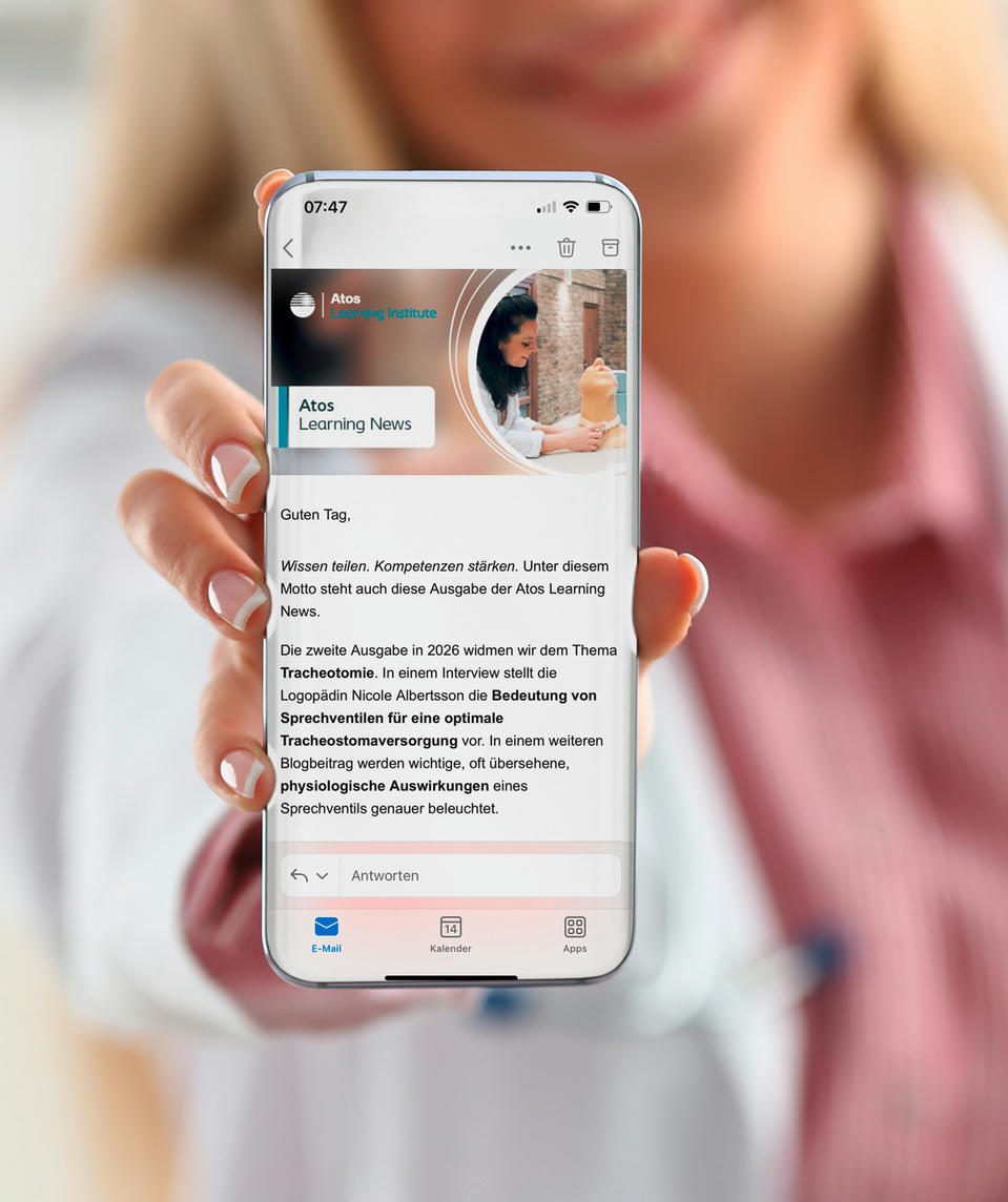 atos-medical-hcp-news-blue-1750x1000 Atos Medical – Ärztin zeigt den Atos Learnin News Newsletter aud ihrem Handy.